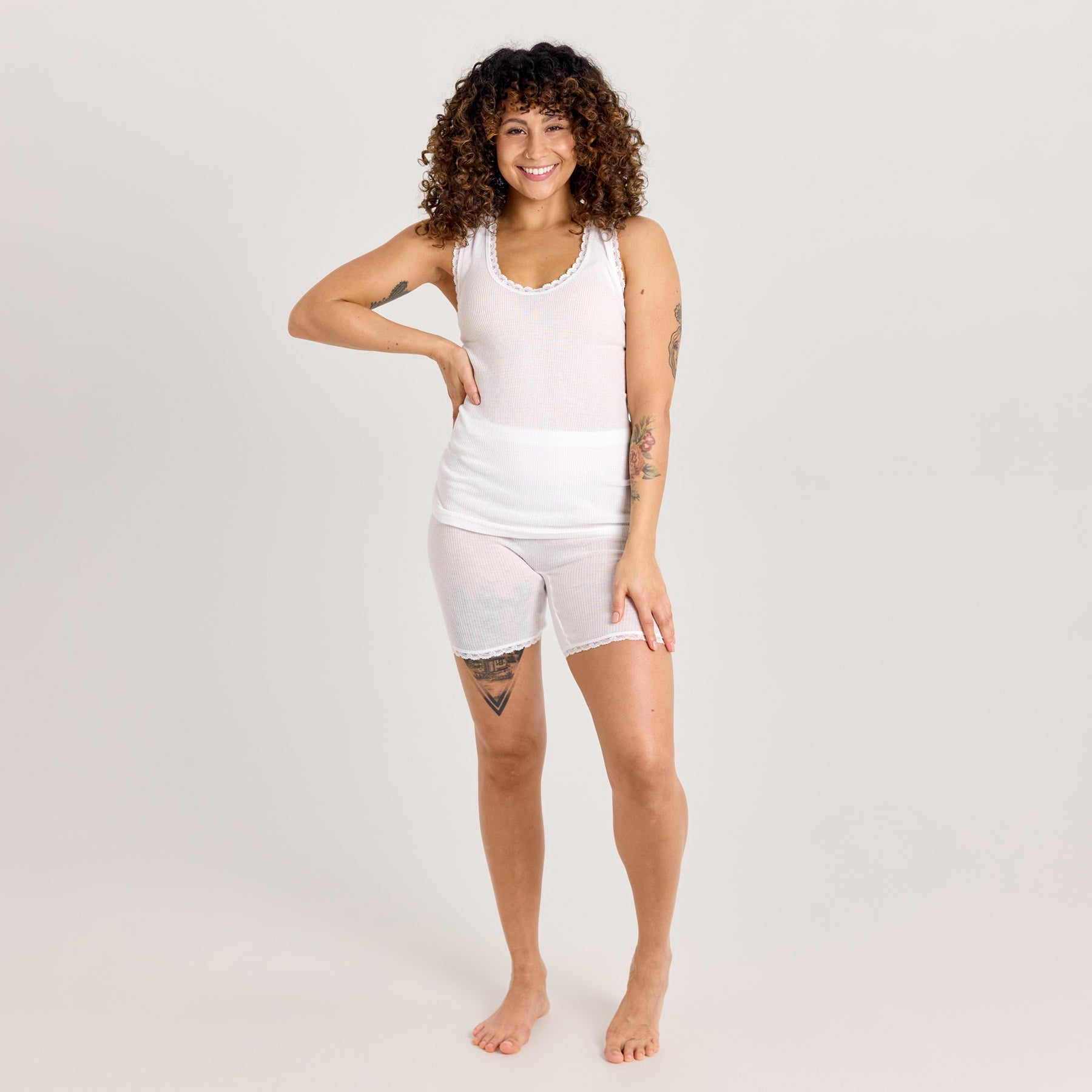 Valkoinen naisten hihaton laamapaita ja laama lahjehousut kuvattuna edestä päin. Alusasu on valmistettu pehmeästä ja hengittävästä puuvillaneuloksesta.