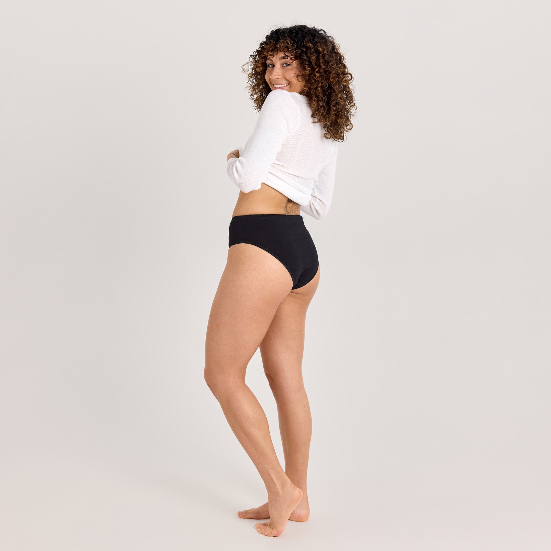 Mustat naisten midi-alushousut kuvattuna sivuttain, jolloin kuvassa näkyy alushousut takaapäin. Hyvin istuvat ja mukavat alushousut.