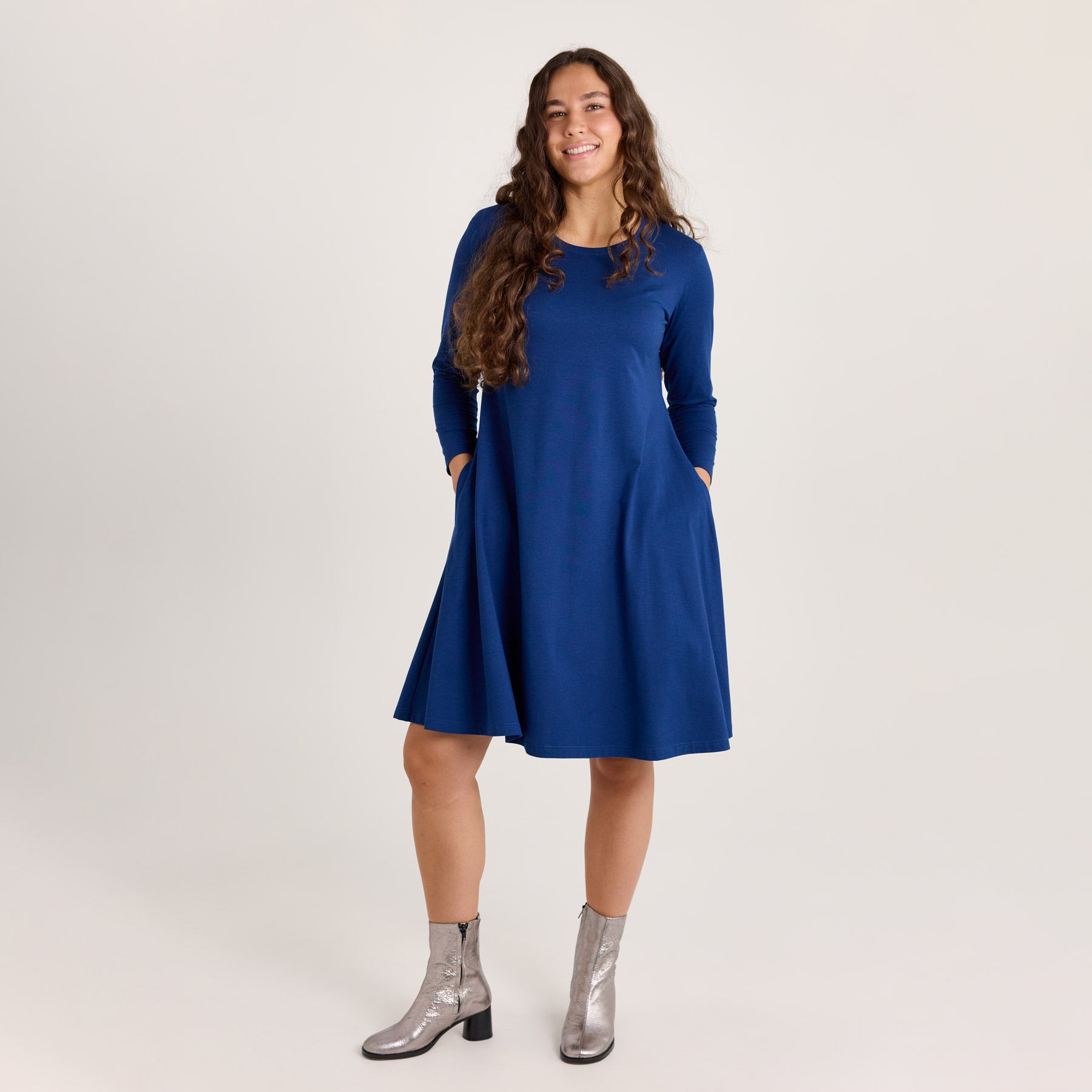 Kellomekko laivastonsinisenä. Noin polvipituinen helma, taskut ja pyöreä pääntie.