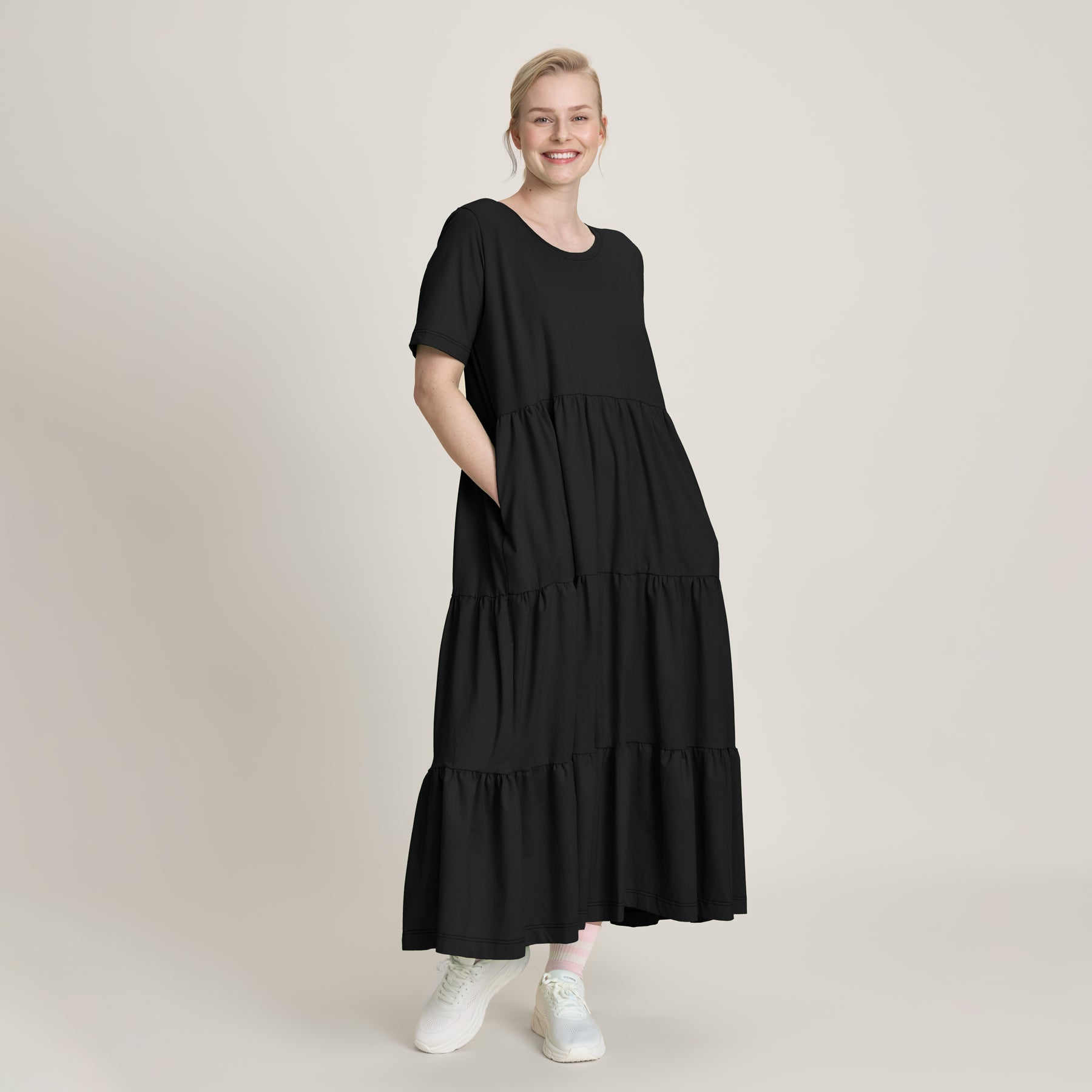 Frillamekko peittää sääret ja sen frillaleikkaukset tuo asuun elävyyttä ja liikkuvuutta. Kevyt ja joustava materiaali tekee mekosta miellyttävän päällä, ja sivutaskut lisäävät käytännöllisyyttä.