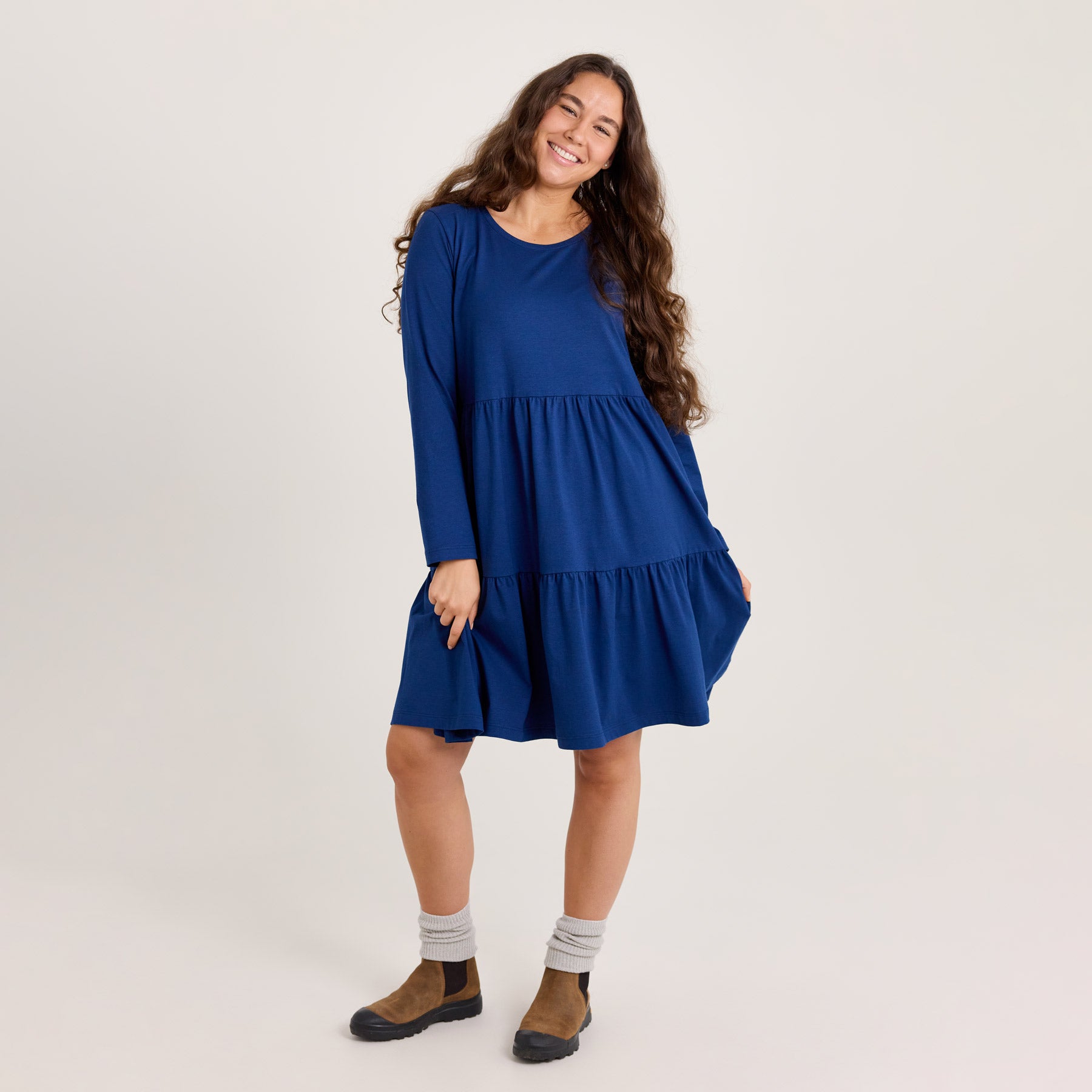 Laivastonsininen frillamekko midipituudella. Mekossa on pitkät hihat, ja helman pituus on noin polven korkeudelle 170 cm pituisella.