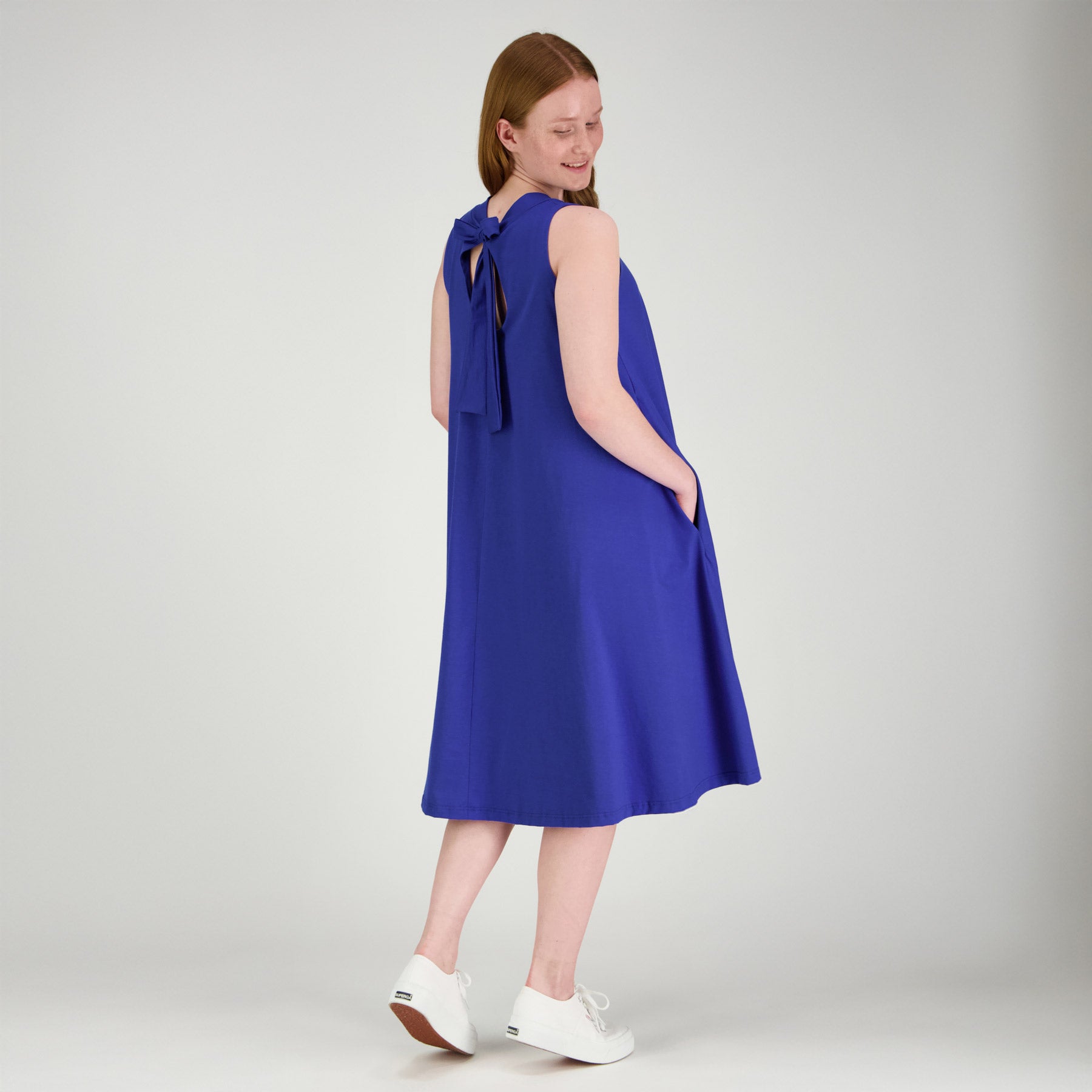 Kirkkaan sininen RUSETTI mekko sivuttain kuvattuna, ja kuvassa näkyy niskassa oleva kaunis rusetti.