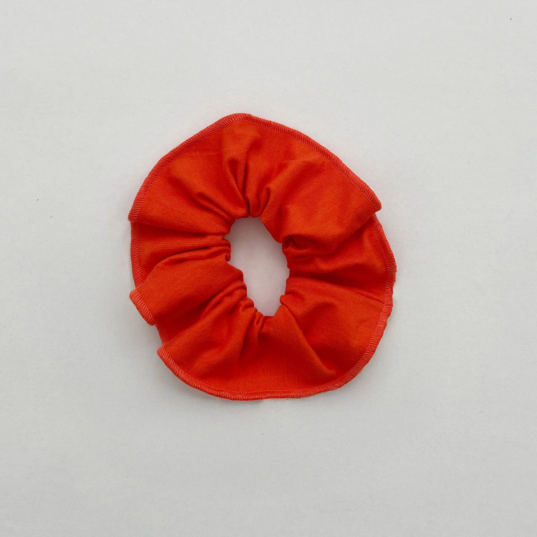 Tomaatinpunaisen värinen hiusdonitsi.