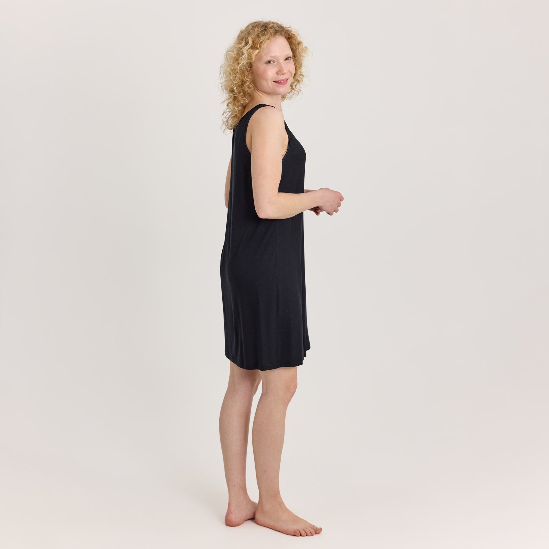 Musta bambuinen alusmekko sivukuvassa, joka näyttää sekä etu- että takaosan laskeutuvuuden. Alusmekon pituus on polven yläpuolelle.