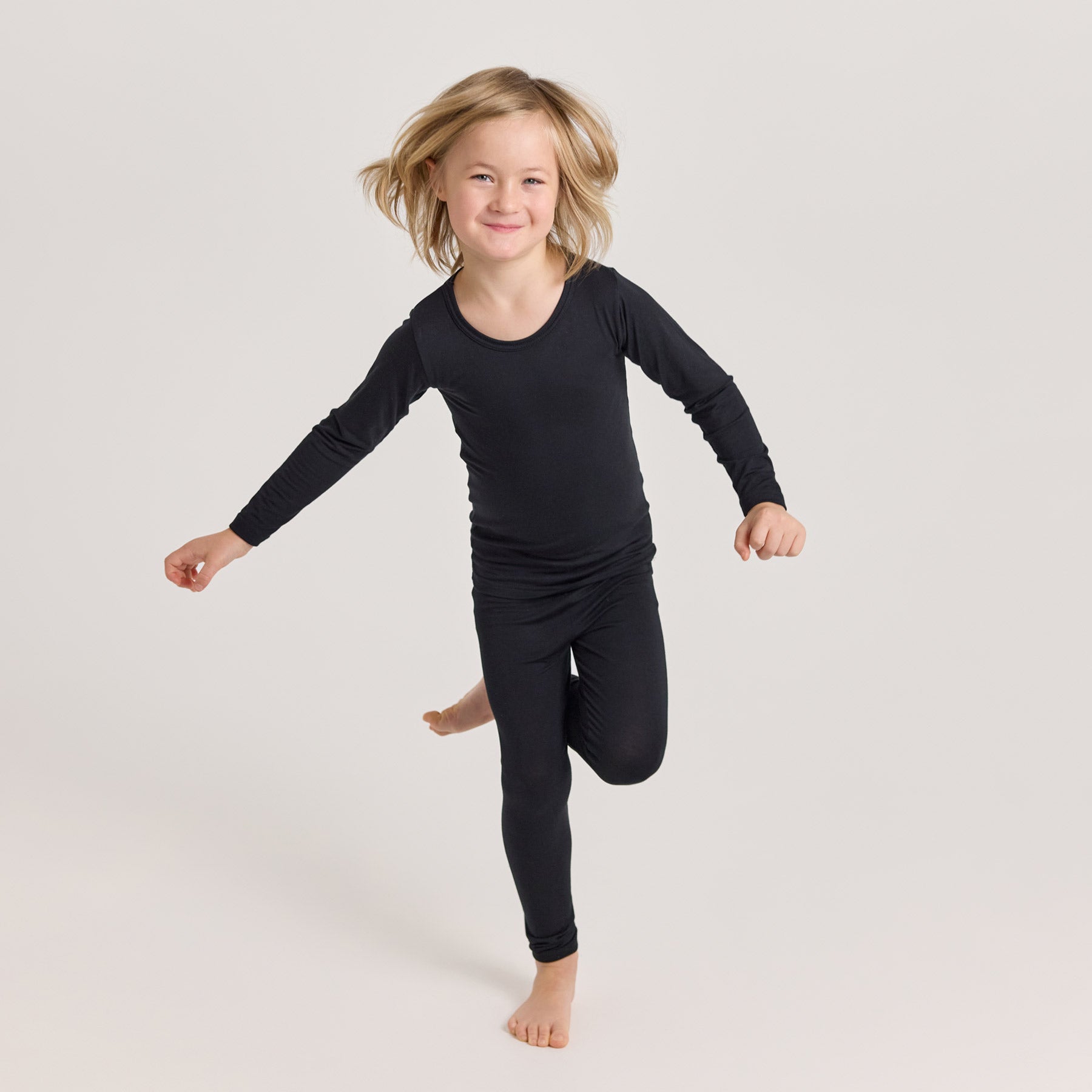 Lapsella on päällä musta HENTO pitkähihainen paita ja HENTO pitkikset. Pehmeä ja mukava bambuasu arkeen ja kerrospukeutumiseen.