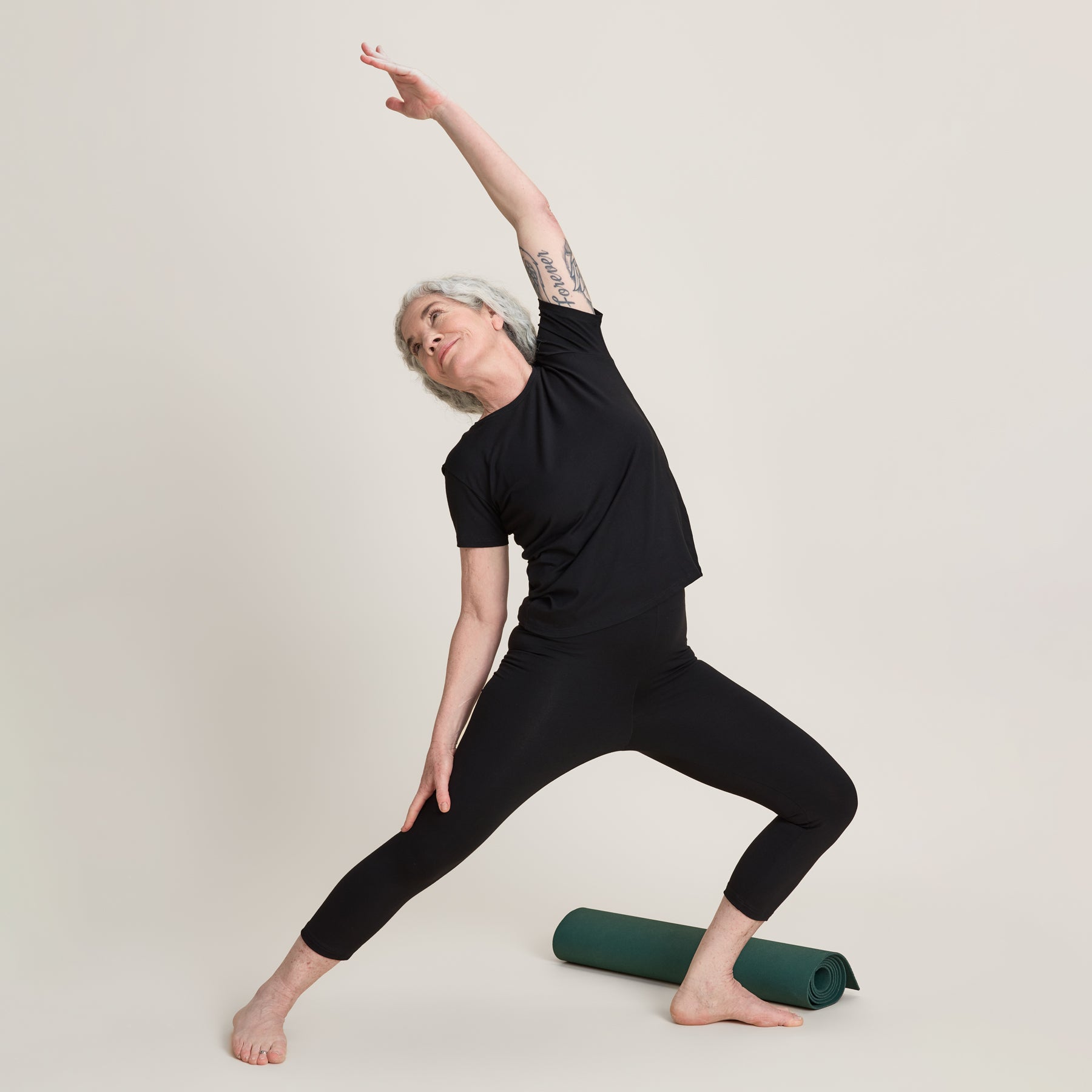 Musta slimmi t-paita yhdessä mustien caprien kanssa. Malli esittelee, että t-paita on joustava, ja sitä voi käyttää urheilussa.