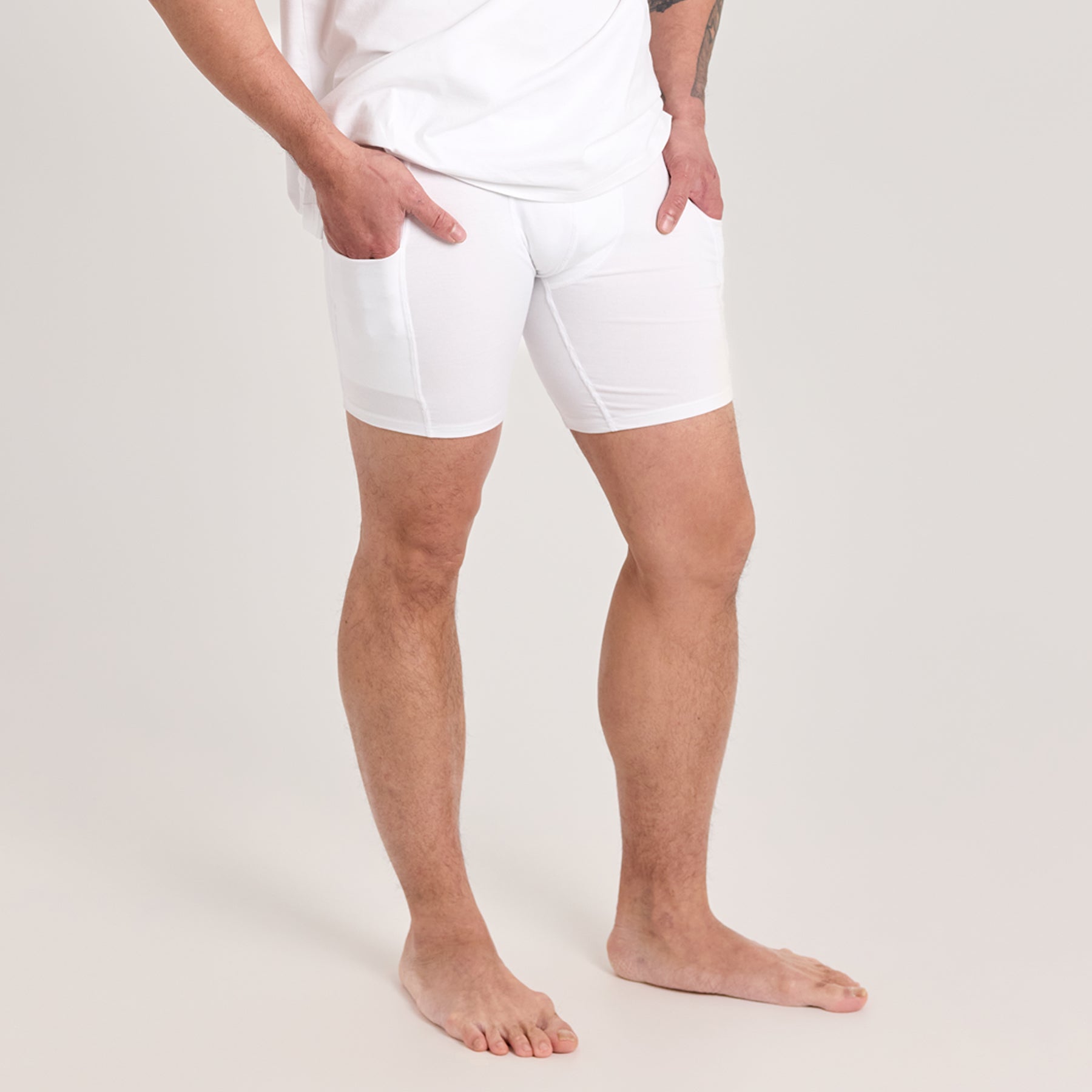 Valkoiset miesten taskukalsarit lähikuvassa. Paksu materiaali ei näy läpi, ja puhelimelle on sopivat taskut molemmilla puolilla reisillä.