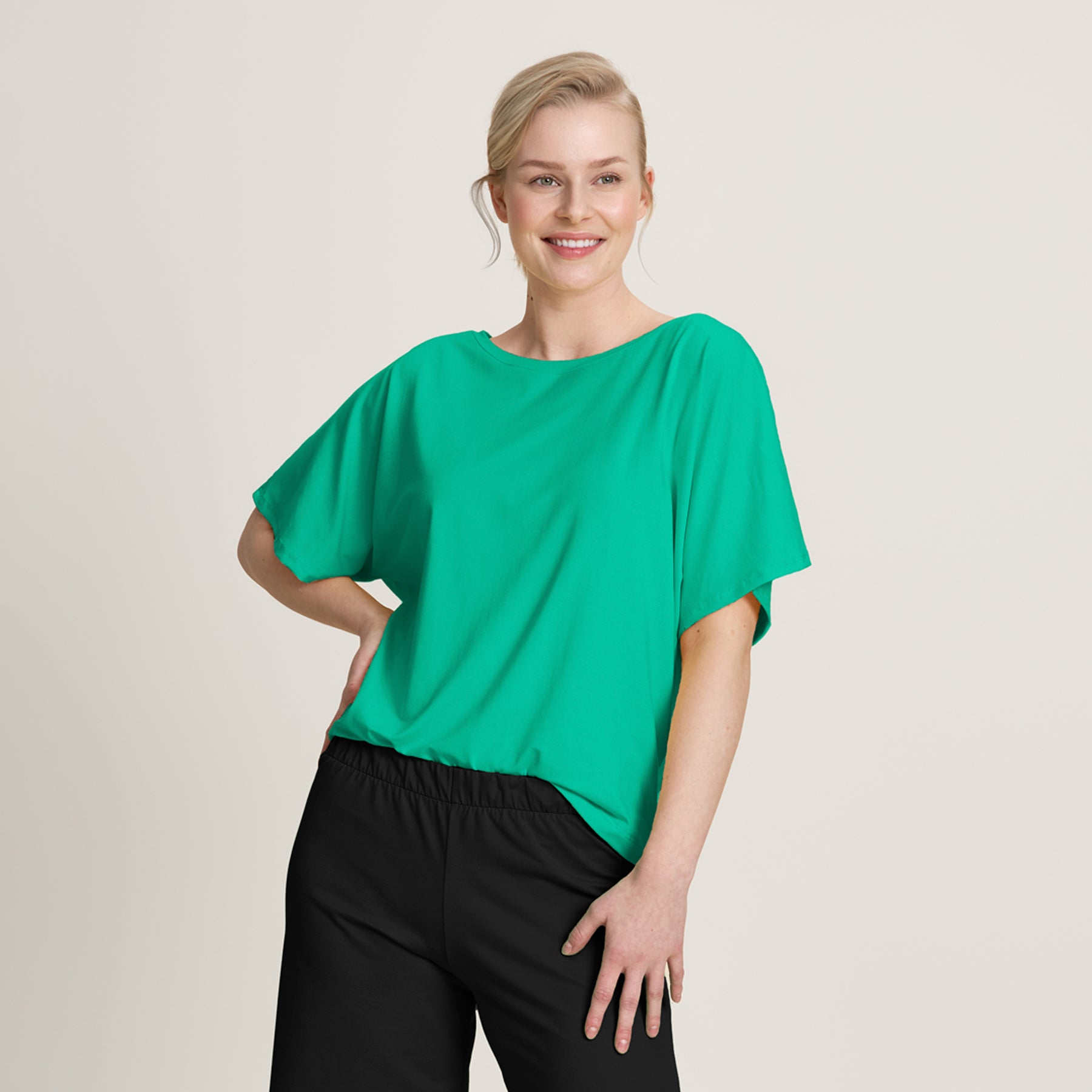 Kirkkaan vihreä bambuneuloksesta valmistettu pusero, jossa on lepakkomaiset hulmuavat hihat ja rento, ilmava leikkaus.