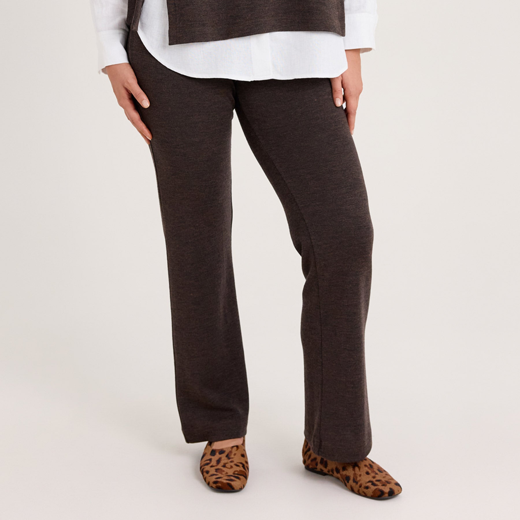 Lähikuvassa meleeratun ruskean väriset rennot neulehousut. Housut ovat paksua 100% merinovillaa.