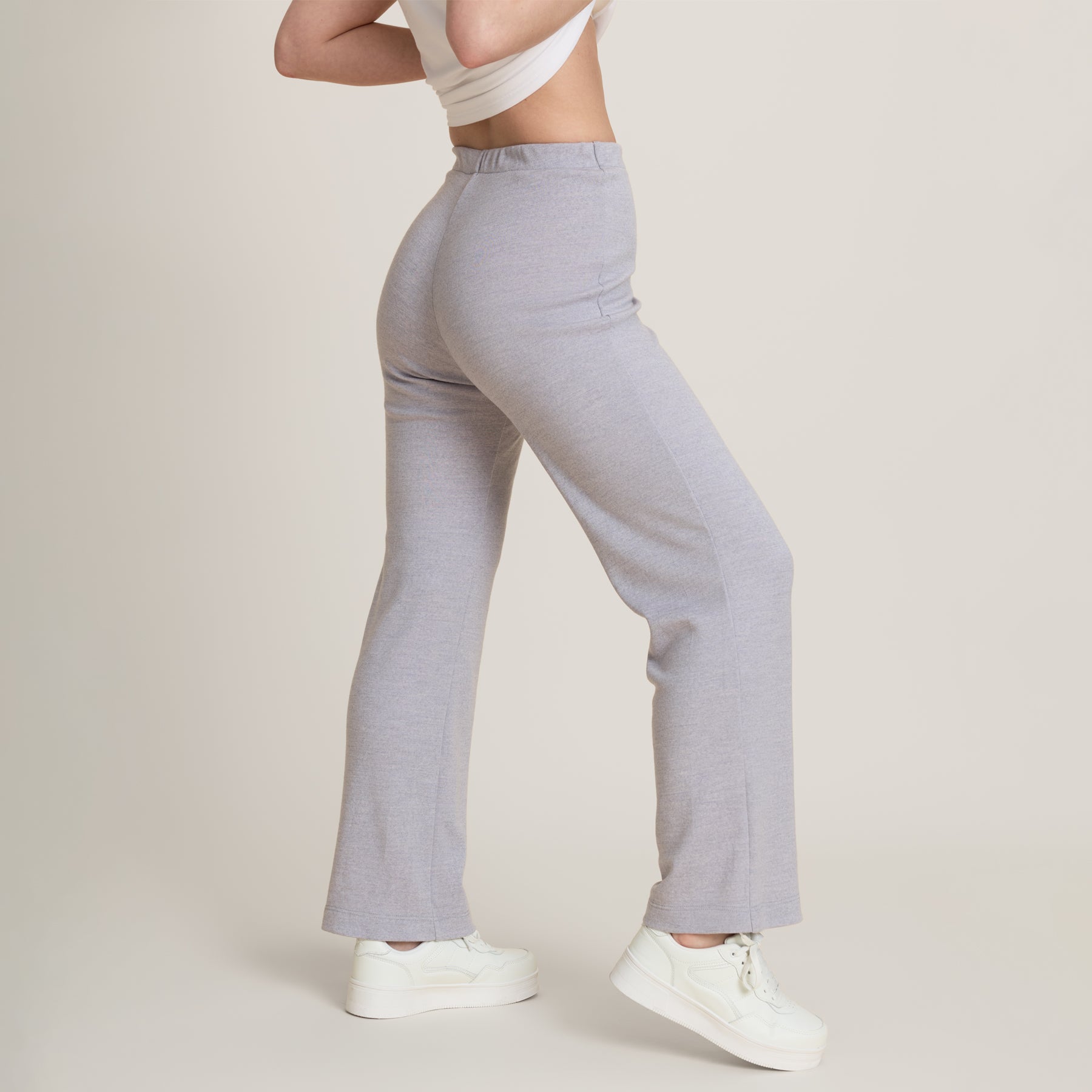 Lähikuvassa harmaat rennot neulehousut. Vyötärö on korkea, ja nousee navan yläpuolelle. Lahkeet ovat suorat ja pitkät. Housuissa ei ole taskuja.