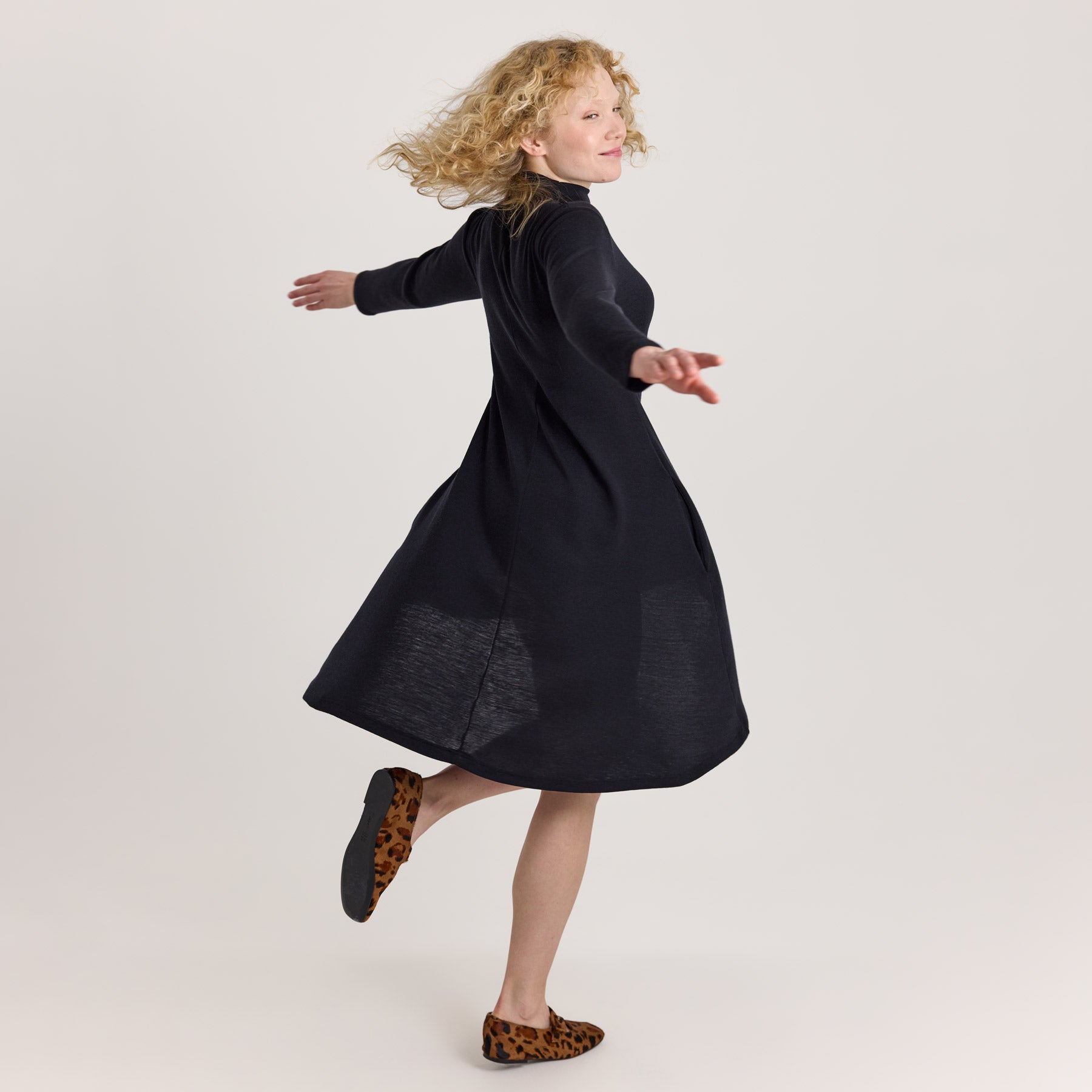 Malli pyörähtää mustassa KAIHO kellomekossa näyttäen merinosilkin ilmavan keveyden ja kauniin läpikuultavuuden.