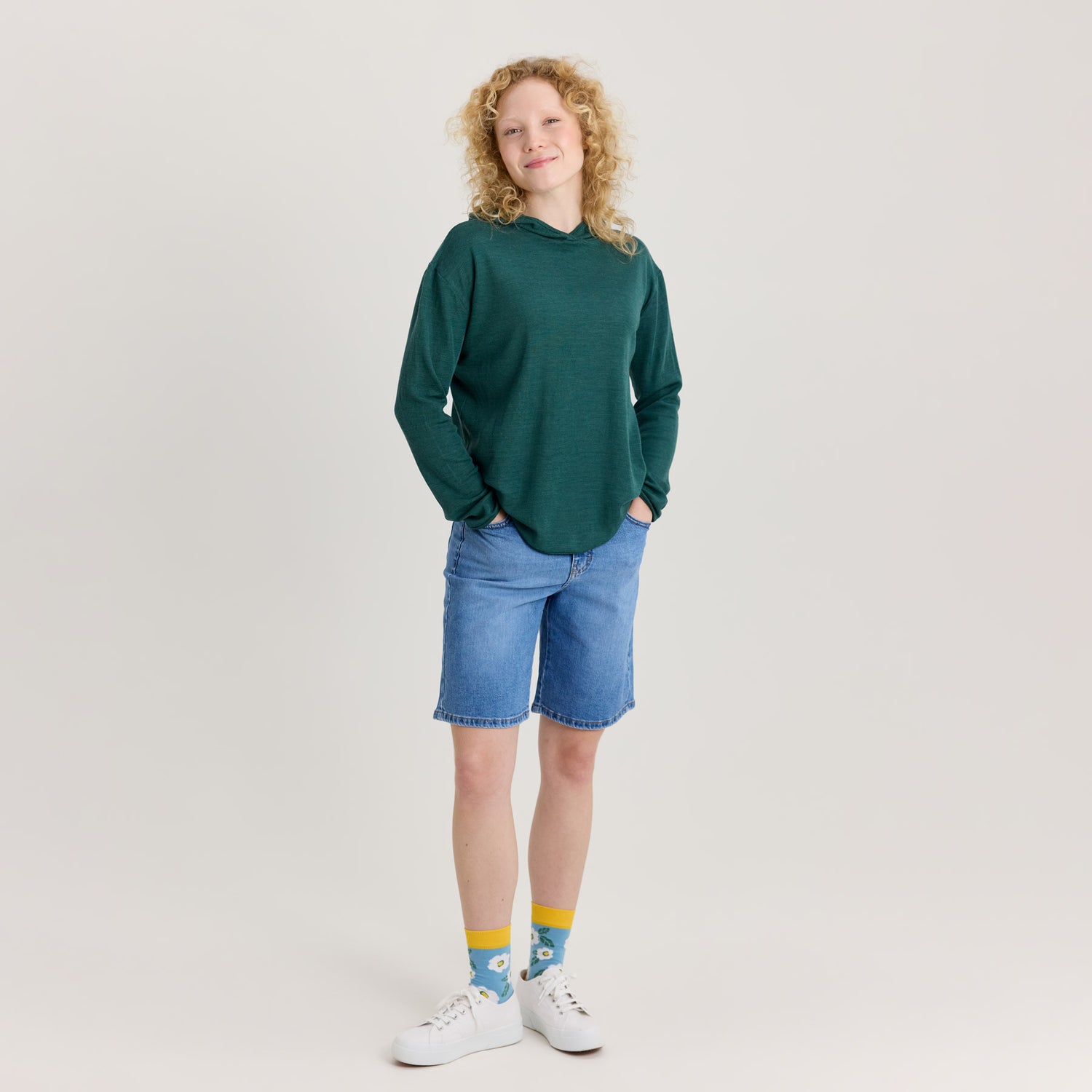 Vihreä unisex huppari ja siniset shortsit. Huppari on pehmeää ja hengittävää merinosilkkiä. Valmistettu Suomessa.