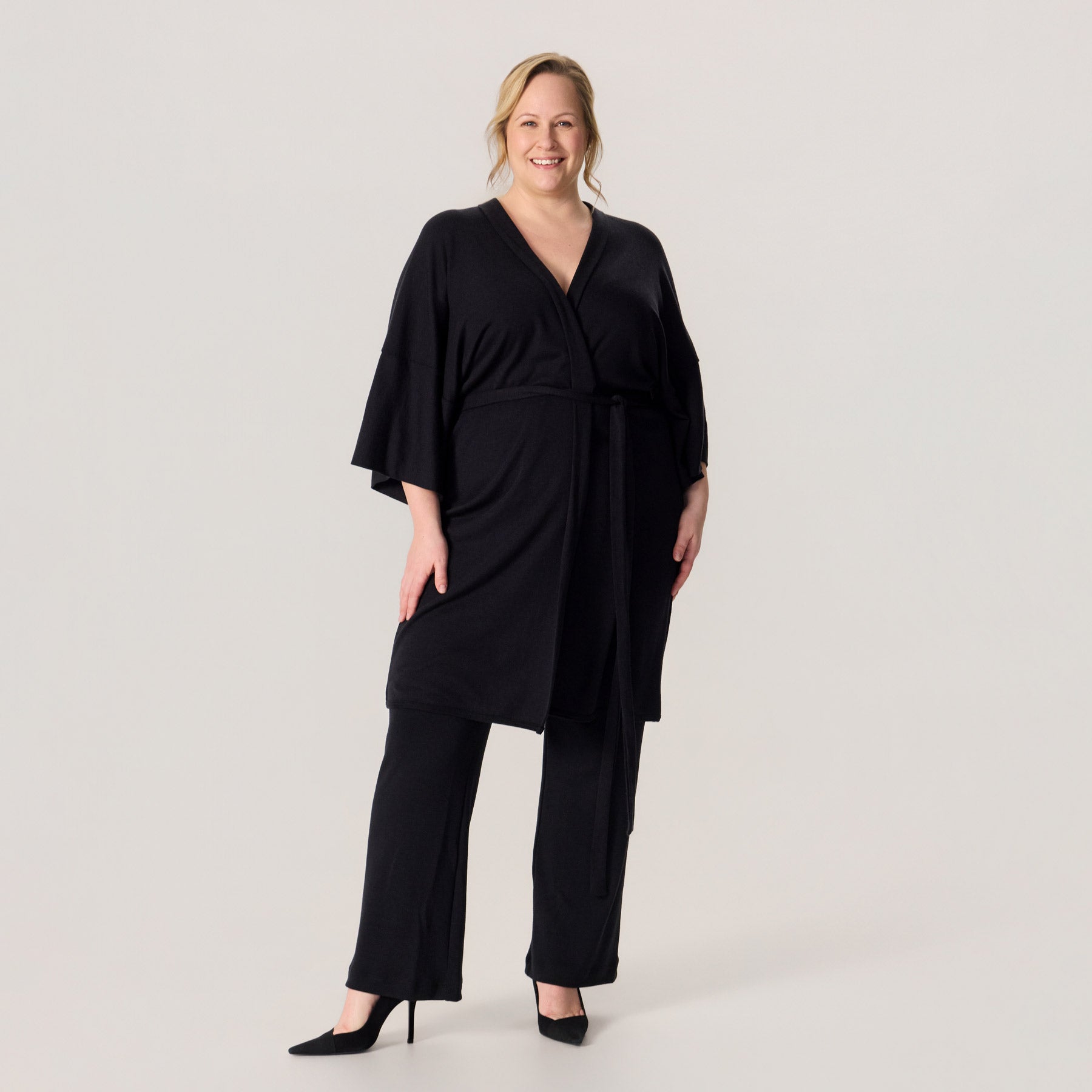 Merinosilkkinen HAIKU kimono ja merinovillaiset rennot neulehousut. Mallilla on korkokengät jalalassa, ja asukokonaisuus on näyttävä ja juhlallinen.