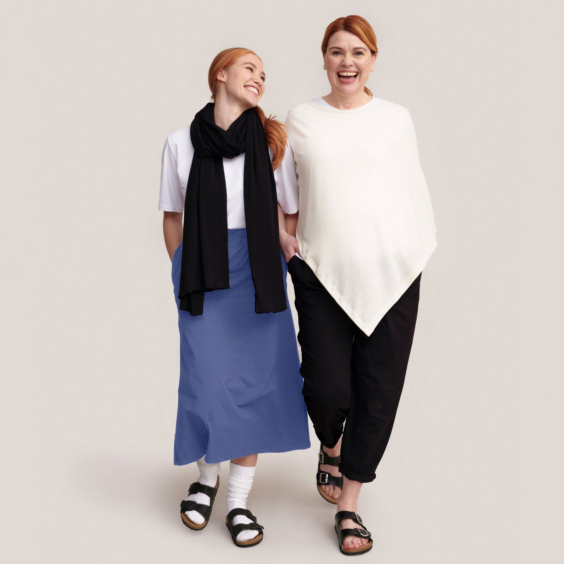 Valkoinen merinosilkkiponcho ja mustat Jokapaikan housut. Toisella kuvan mallilla on yönsininen Midihame ja valkoinen t-paita.