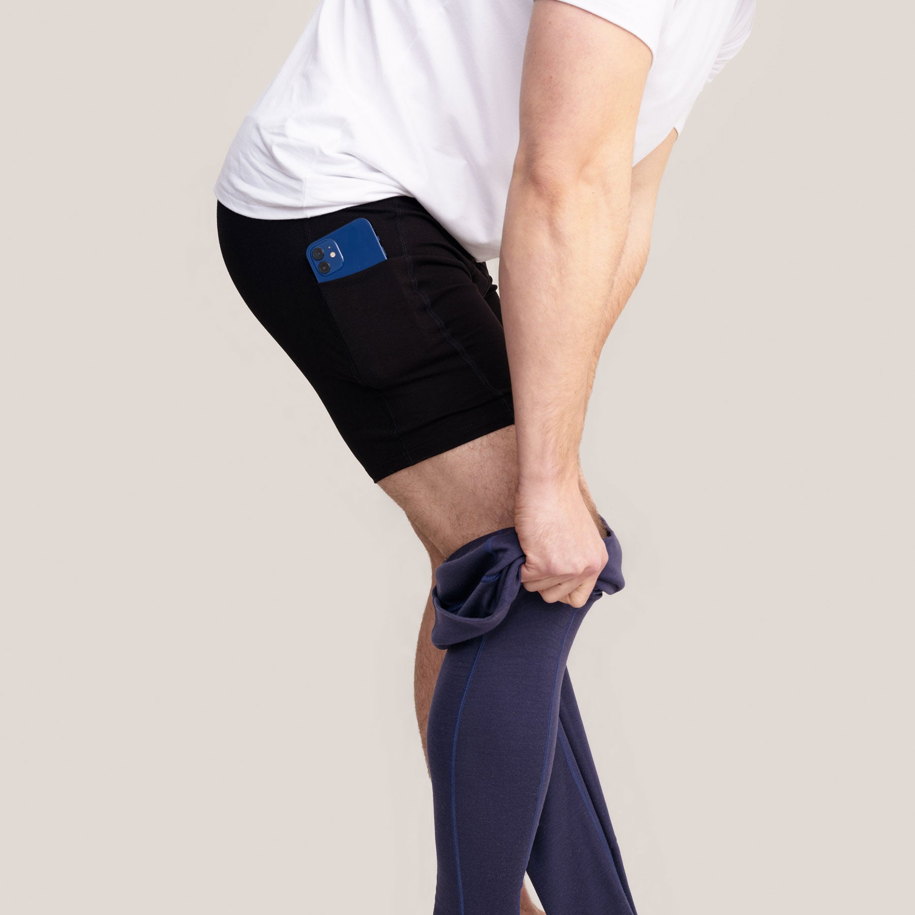 Lähikuva miesten taskukalsareista. Taskussa on puhelin.