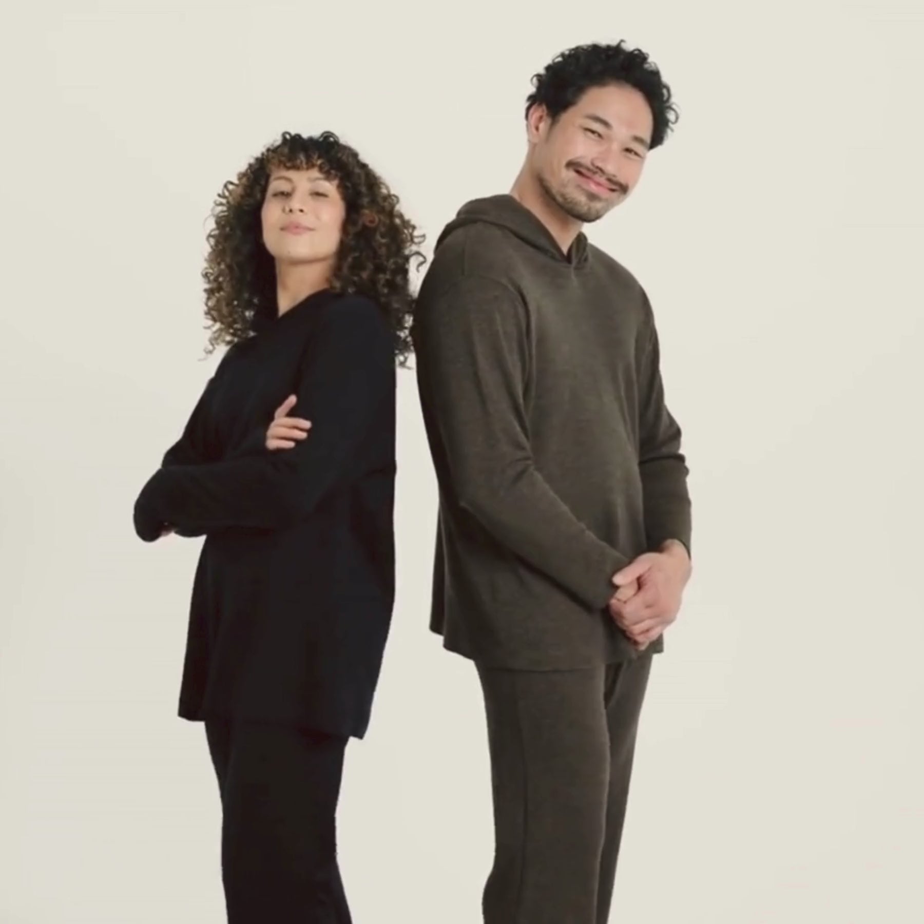 Videolla on musta ja meleerattu ruskea suora huppari. 100% merinovillaa valmistettu Kangasalla.