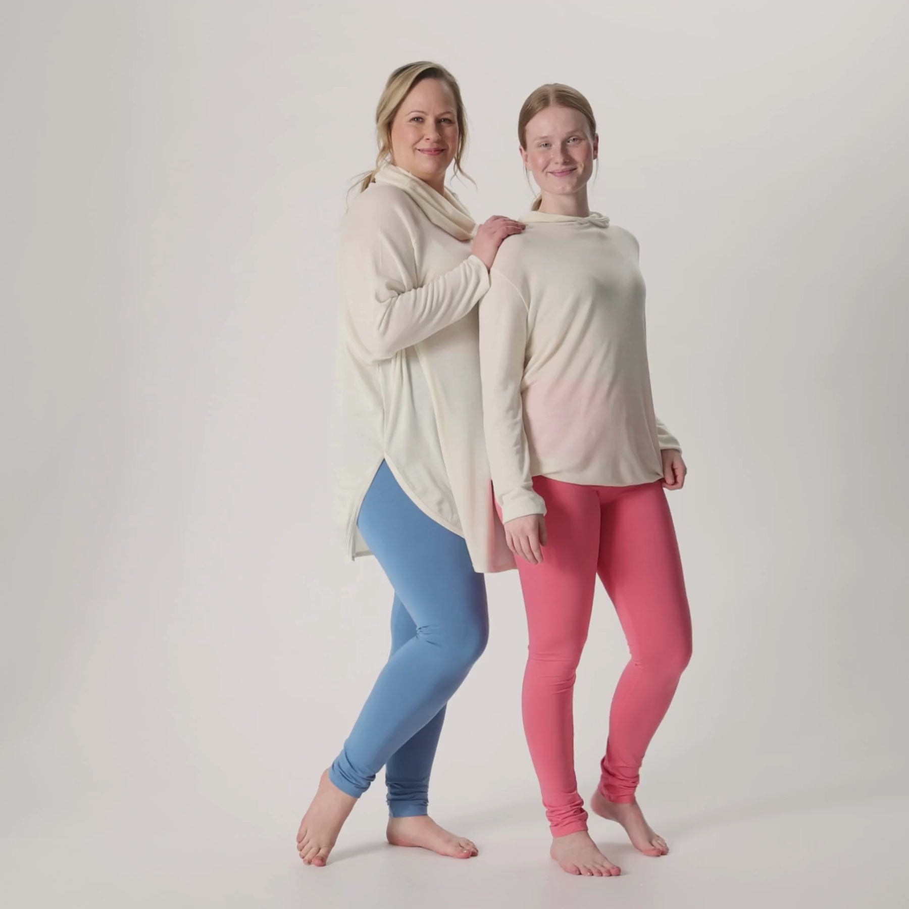 Videolla on harmaansiniset ja korallipinkit LEMPI bambuleggingsit yhdistettynä luonnonvalkoisiin merinosilkkisiin neuletunikaan ja unisex-huppariin.