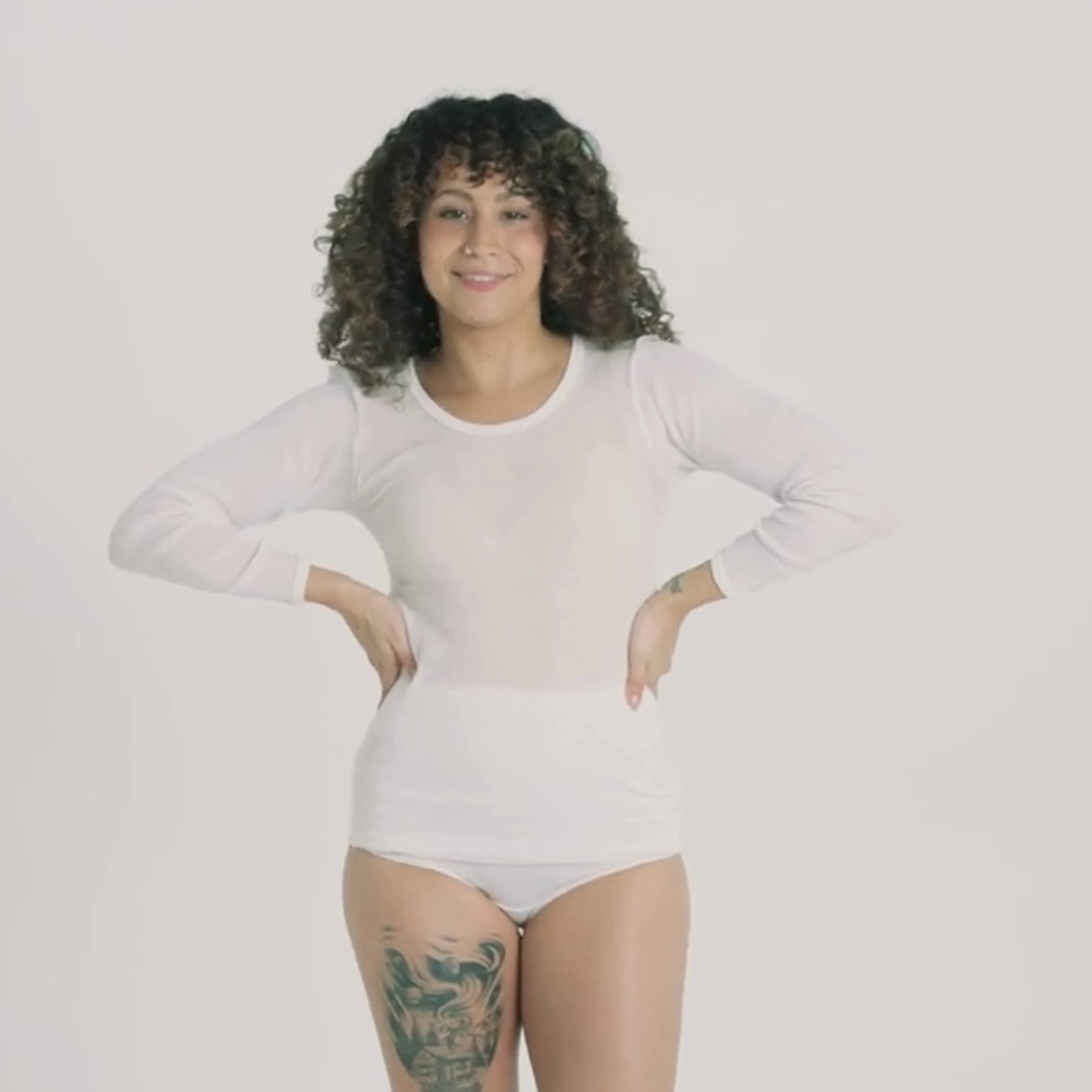 Videolla mallilla on päällä valkoinen naisten pitkähihainen laamapaita.