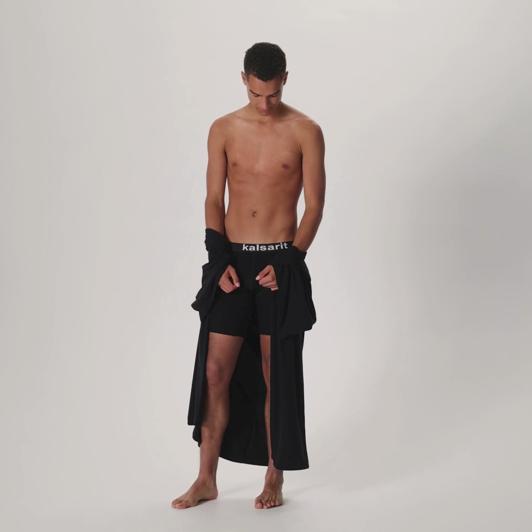 Videolla miehen päällä musta HAIKU kimono ja miesten taskukalsarit.