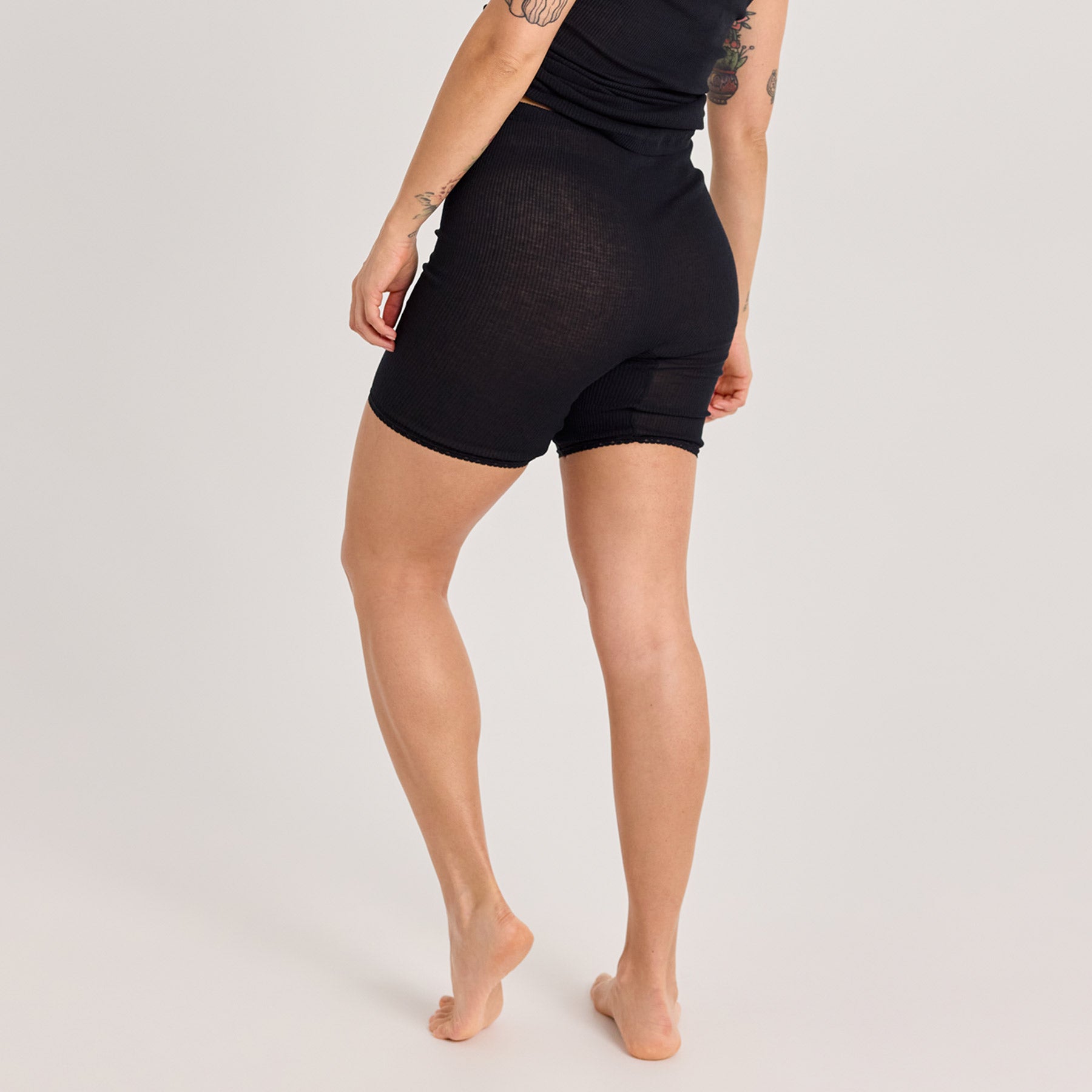 Lähikuva mustista naisten laama lahjehousuista takaapäin. Valmistettu pehmeästä ja hengittävästä 100% puuvillaneuloksesta.