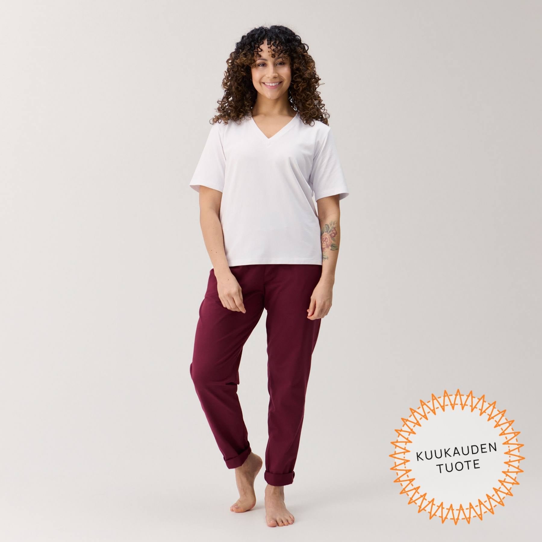 Viininpunaiset Jokapaikan housut edestä päin kuvattuna. Housujen lahkeet ovat kääritty ylös.