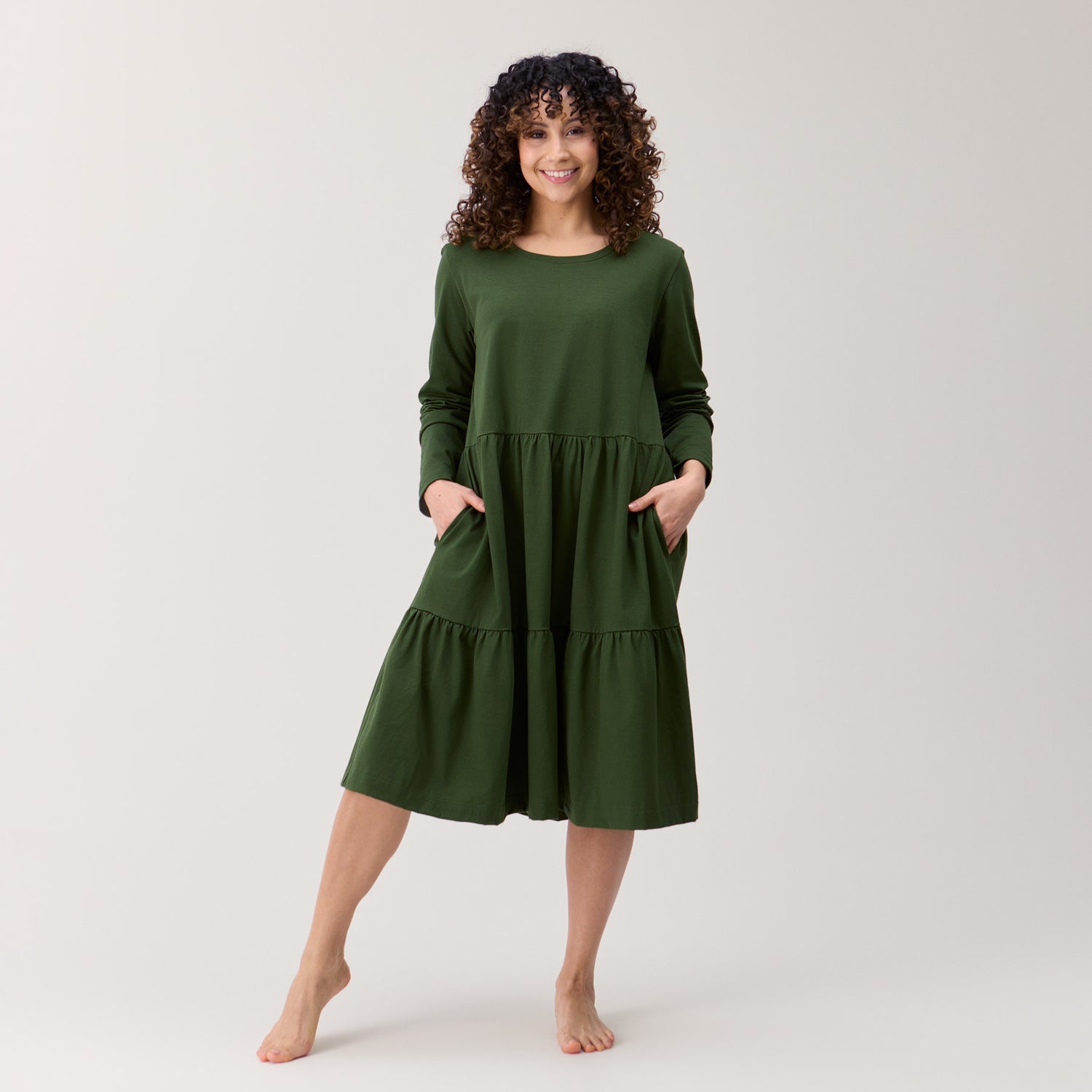 Pitkähihainen midipituinen frillamekko maastonvihreä. Mekossa on taskut, pyöreä pääntie ja polvipituinen helma. Valmistettu Suomessa, Kangasalla.