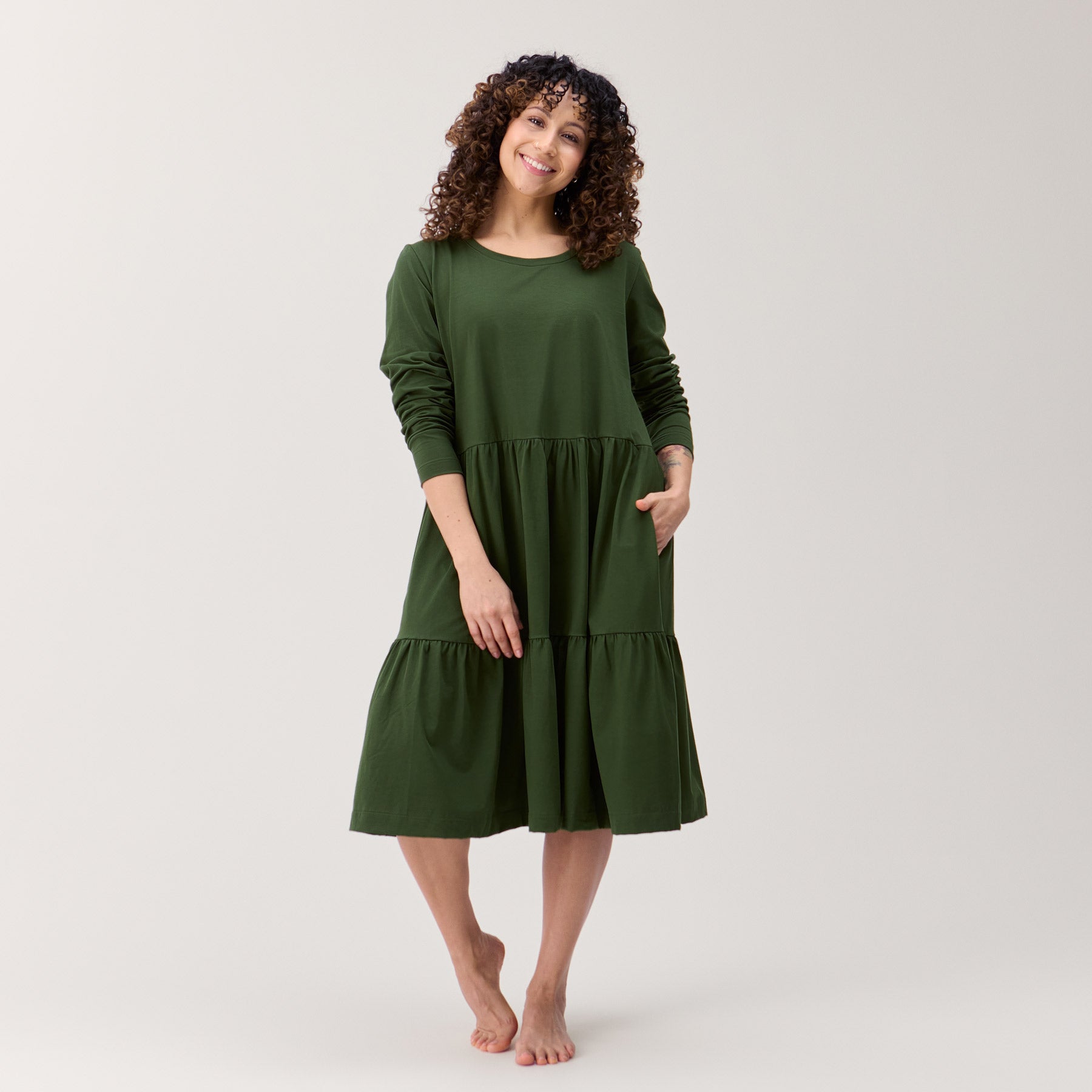 Monikäyttöinen pitkähihainen mekko. Mekossa on runsas helma, jossa on kaksi frillakerrosta. Kuvasa on maastonvihreä frillamekko.