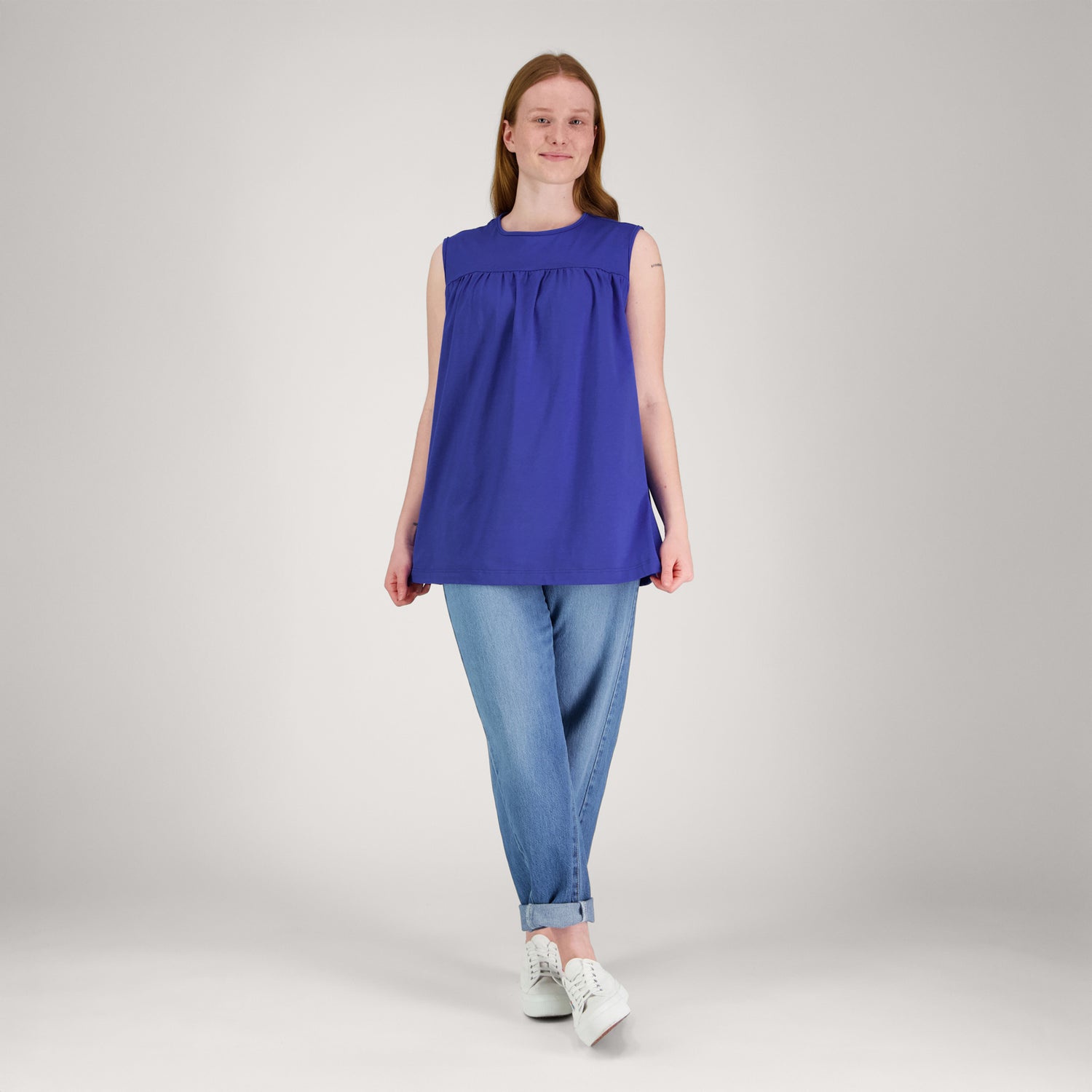 Kirkkaan sininen ILO toppi edestä päin naisen päällä. Topissa on rinnan yläpuolella rypytys, pyöreä pääntie ja toppi on hihaton.