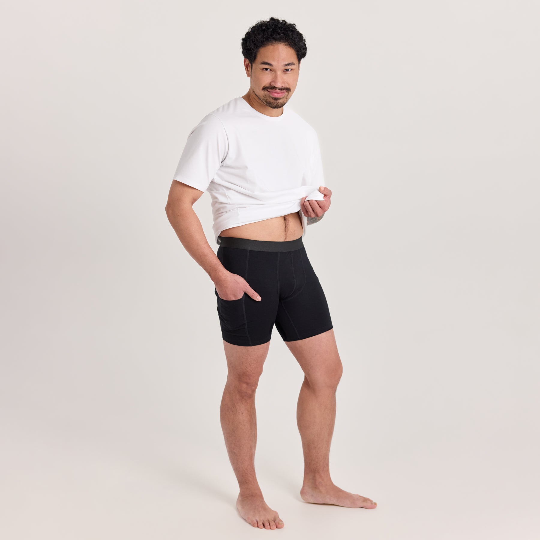 Mustat miesten taskukalsarit valkoisen miesten t-paidan kanssa. Hengittävät ja mukavat alushousut, jotka on valmistettu paksusta bambuneuloksesta. Kummallakin sivulla käytännölliset reisitaskut.