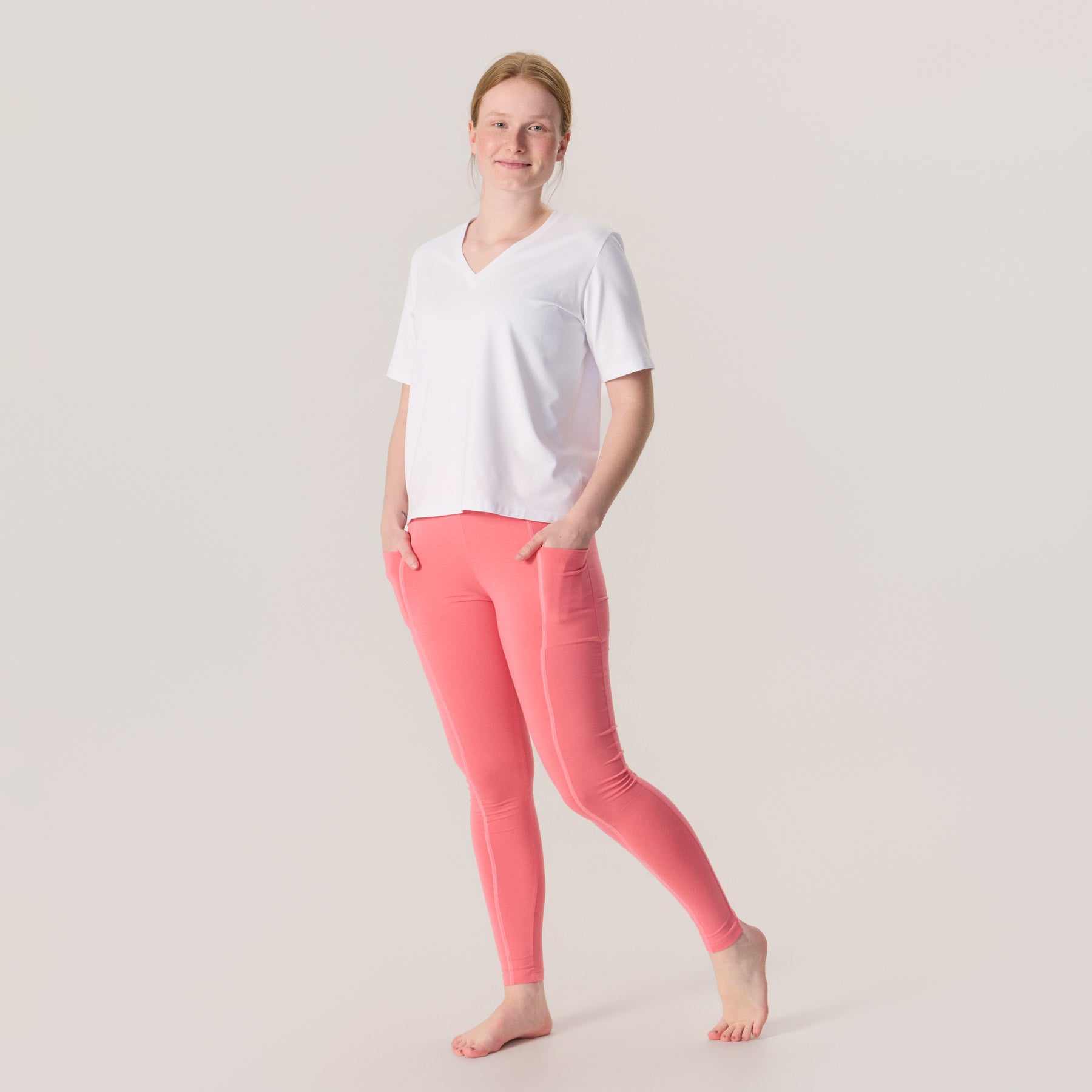 Korallipinkit LEMPI treenileggingsit. Napakat, pehmeät ja läpikuultamattomat treenileggingsit vapaa-aikaan ja liikuntaan. Kuvassa treenileggingsit on yhdistetty valkoisen jokapaikan t-paidan kanssa.