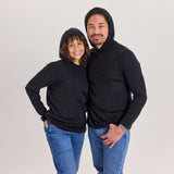 Nainen ja mies mustassa merinosilkkisessä unisex-hupparissa huput päässä.