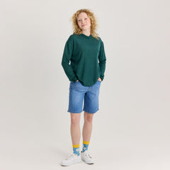 Vihreä unisex huppari ja siniset shortsit. Huppari on pehmeää ja hengittävää merinosilkkiä. Valmistettu Suomessa.