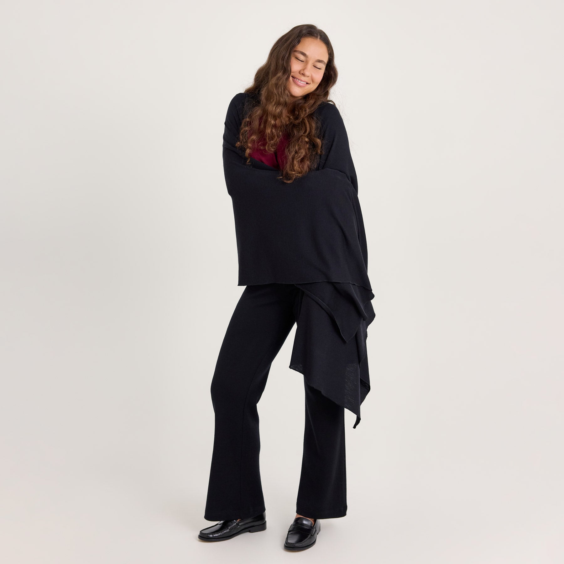 Malli on kietoutunut mustaan KAIHO merinosilkkihuiviin. Huivia voi käyttää shaalina.