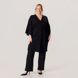 Merinosilkkinen HAIKU kimono ja merinovillaiset rennot neulehousut. Mallilla on korkokengät jalalassa, ja asukokonaisuus on näyttävä ja juhlallinen.