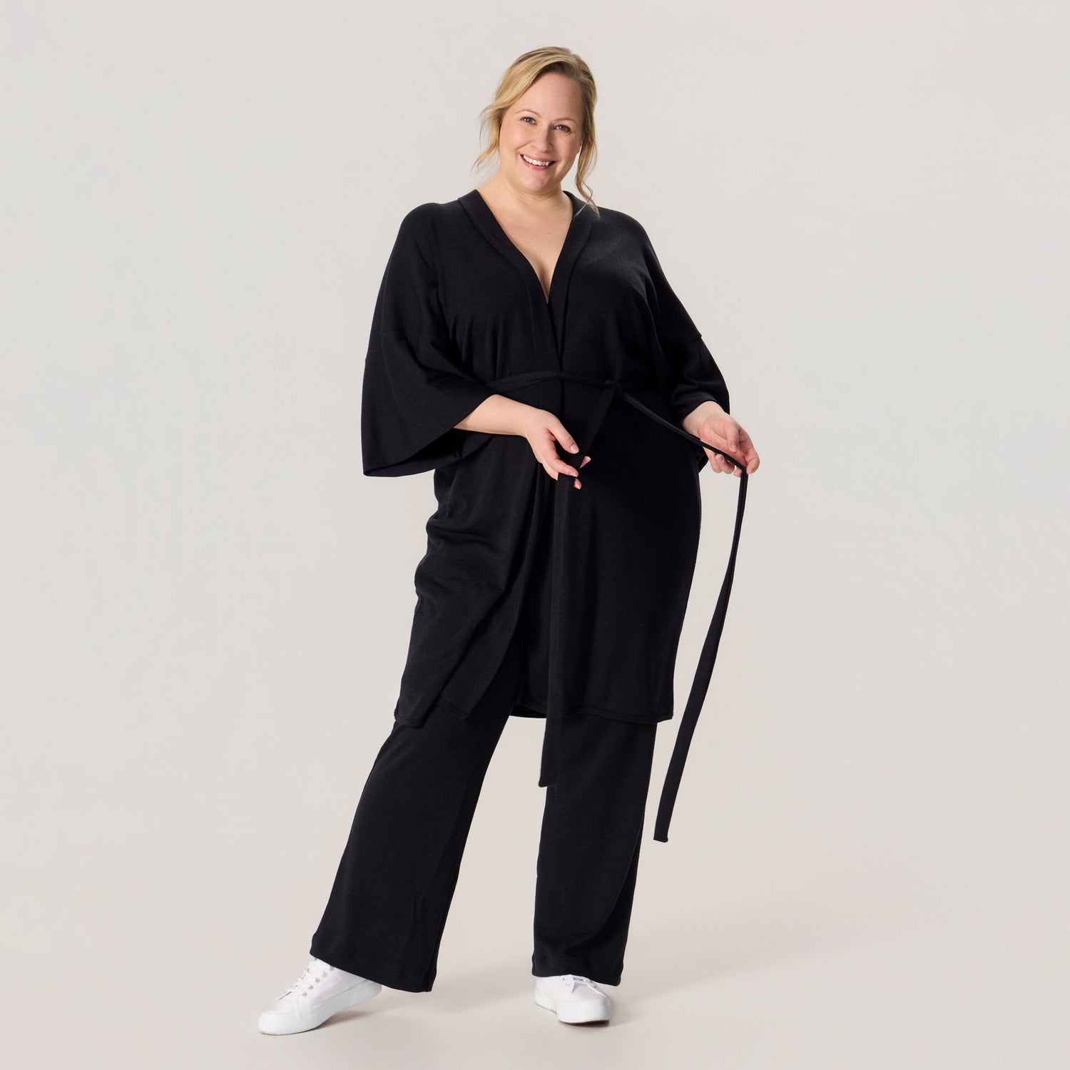 HAIKU kimono ja rennot neulehousut merinovillasta. Mallilla on jalassa valkoiset tennarit, ja asukokonaisuus on rento ja näyttävä arkeen.