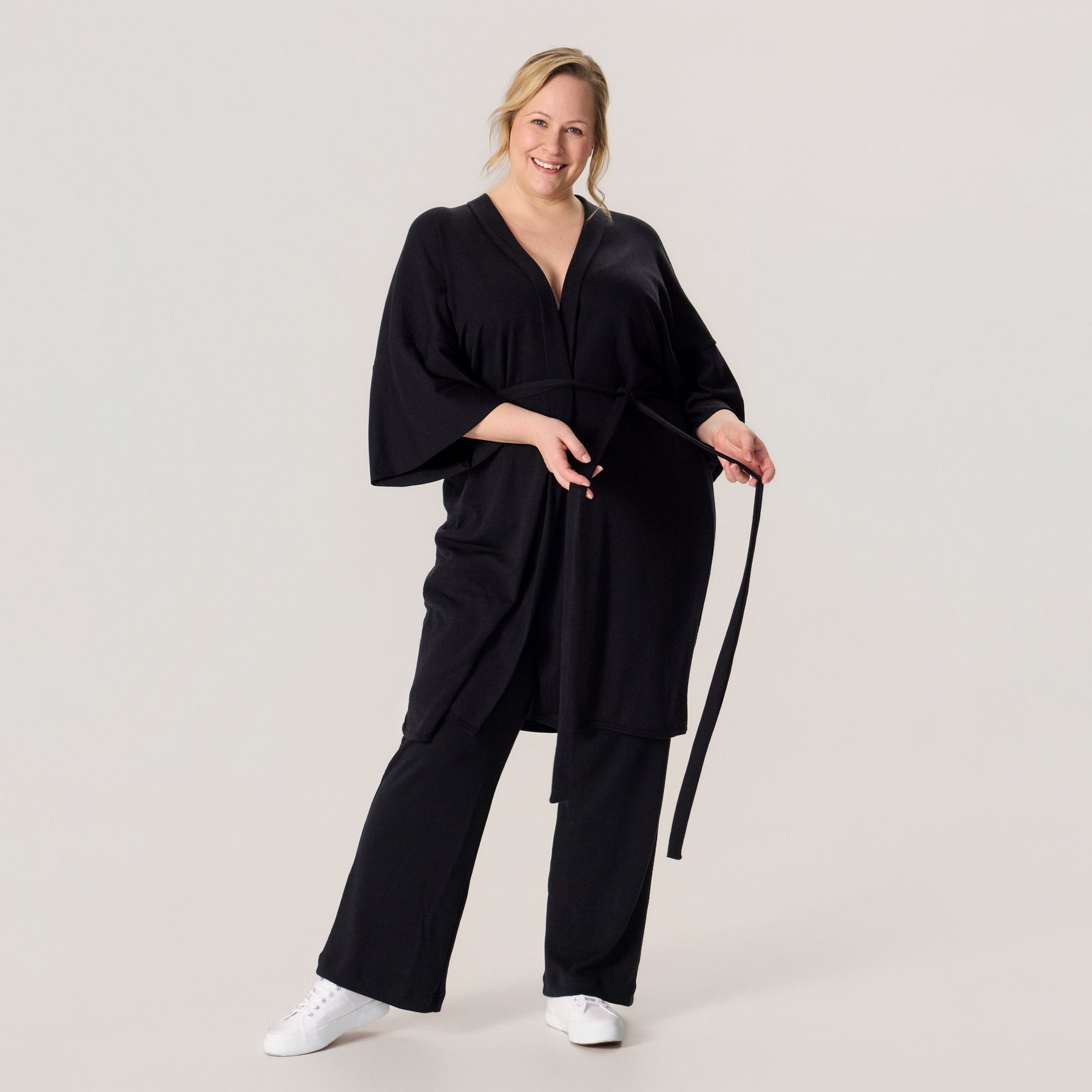 HAIKU kimono ja rennot neulehousut merinovillasta. Mallilla on jalassa valkoiset tennarit, ja asukokonaisuus on rento ja näyttävä arkeen.