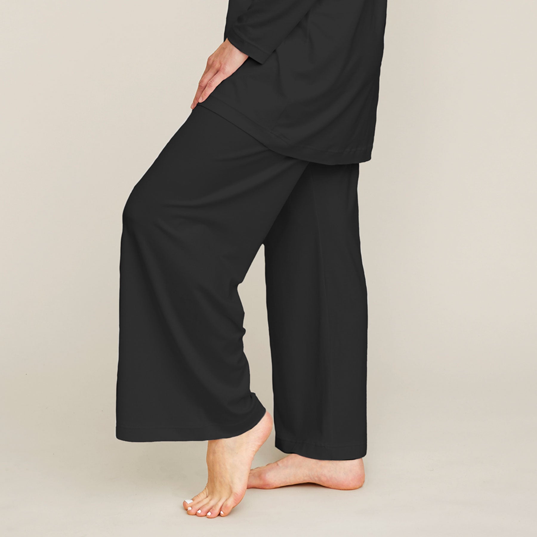 Lähikuva mustista pyjamahousuista. Housut ovat malliltansa väljät ja lahkeet ovat leveät.