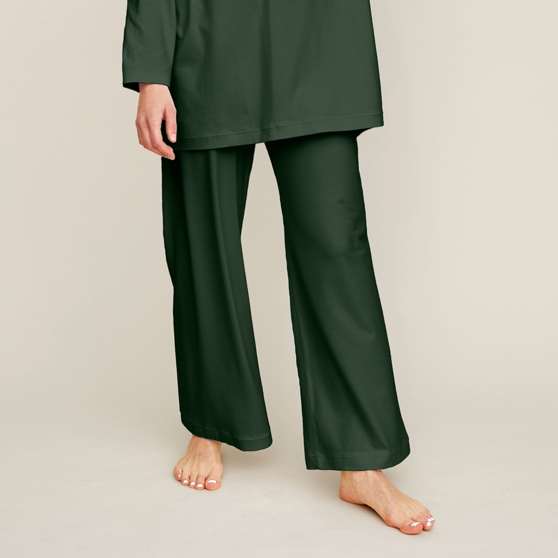 Lähikuva vihreistä pyjamahousuista. Housut ovat malliltansa väljät ja lahkeet ovat leveät.